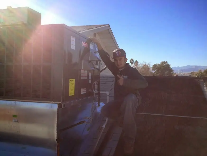 HVAC technician performing Heat Pump Repair on a rooftop unit in Poplar Bluff